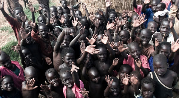 photo of many Ugandan children raising their hands in thanks